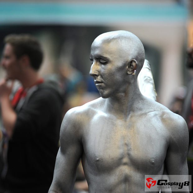 A man dressed as the Silver Surfer walks through the exhibition