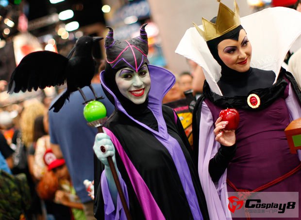 Attendees in costume walk the convention floor